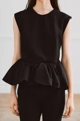 Top negro de manga sisa de Zara Woman Collection, confeccionado en mezcla de algodón, con cuello redondo y bajo acabado en peplum fruncido.
