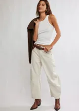 Jean de algodón color crema, tiro medio, con corte relajado y piernas anchas que terminan a la altura del tobillo. Presenta costuras visibles y un diseño de paneles en las rodillas.