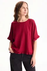 Blusa de lino color crudo, de manga corta con detalles de volados en las mangas y en el ruedo.