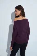 Top de manga larga con escote bote amplio, diseñado para usar ligeramente caído sobre los hombros. Presenta una silueta entallada y tejido liso, liviano y adaptable al cuerpo.