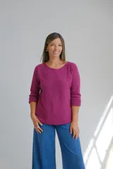 Sweter de punto color magenta, con escote redondo a la base y mangas tres cuartos con dobladillo.