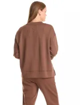 Buzo deportivo de cuello redondo, con hombros caídos y mangas largas con puños. Presenta costuras decorativas tipo pespunte en la parte frontal y en las mangas, con un diseño de ruedo recto y tajos laterales.