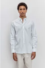 Camisa de manga larga en color celeste con estampado de rayas verticales finas, cuello abotonado y cierre frontal con botones.