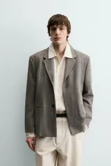 Blazer de corte slim fit confeccionada en tejido con viscosa, con cuello de solapas de muesca, cierre frontal de un botón, bolsillos de solapa en la cadera y bolsillo de vivo en el pecho.