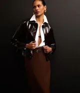 Pollera midi marrón de corte recto, con cinturón de hebilla redonda y detalle de encaje en la espalda.