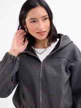 Campera de paño con capucha, cierre frontal completo y puños elásticos. Presenta un diseño de corte holgado y textura suave.