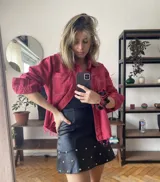 Camisa de denim celeste claro, de corte holgado, con cuello clásico, cierre frontal con botones a presión y bolsillos con solapa en el pecho.