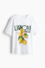 Remera de algodón de corte holgado con cuello redondo y hombros caídos. Presenta un estampado frontal con limones y la inscripción 'Limoni Freschi'.