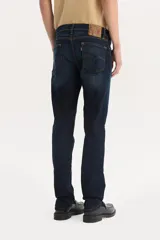 Pantalón de jean azul oscuro, corte slim, tiro bajo y confección stretch.