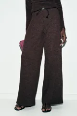 Pantalón de tiro alto y pierna recta, confeccionado en tejido piqué color beige. Presenta cintura elástica y un cinturón fino a contraste en color negro con detalle de pieza metálica central.