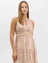 Vestido largo de fiesta con escote halter y apertura frontal en forma de gota. Presenta una faja en la cintura decorada con apliques de strass y una falda maxi estructurada en paneles escalonados con pliegues. Posee cierre invisible en la espalda y forro interno.