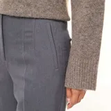 Pantalón de corte recto y tiro alto en color gris, con diseño clásico de vestir, pinzas frontales y cierre oculto.