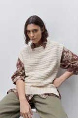 Chaleco tejido de punto color blanco, de calce relajado y silueta recta, con cuello redondo, hombros caídos y diseño calado.