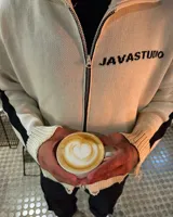 Sweater de punto color blanco con diseño gráfico negro en la espalda, cuello alto y detalles desgastados en los bordes.