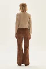 Sweater de punto color beige, con cuello redondo, manga larga y puños acanalados.