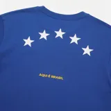 Remera Air Jordan de manga corta y cuello redondo, color azul, con diseño gráfico estampado en el frente que dice "BRASIL" integrando el logo Jumpman en color amarillo en lugar de la letra "A".