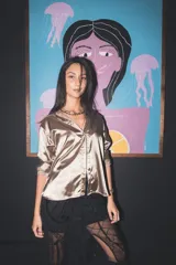 Falda midi negra transparente con bordados geométricos y ornamentales, de corte recto.