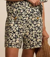 Short de tiro alto confeccionado en viscolino con estampa de caracoles, bolsillos delanteros con botones y detalle de pespunte.