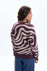 Buzo de punto con estampado de ondas en color bordó y beige, cuello redondo y mangas largas.