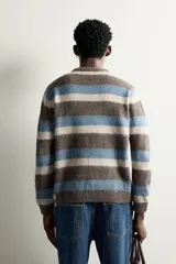 Sweater de punto con textura efecto pelo, cuello redondo, manga larga y diseño a rayas horizontales en tonos marrón, celeste y beige.