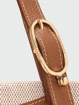 Mini bolso cruzado de Longchamp, diseñado con la estética de un par de manoplas de lana verde con franjas blancas y bordó, y solapa de cuero marrón con cierre de broche a presión.