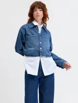 Sobrecamisa cropped de denim azul medio, con cuello clásico, mangas largas globo y dos bolsillos de parche con tapa en el pecho.