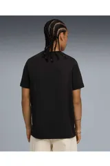 Remera Puma de manga corta y cuello redondo en color negro, con un estampado gráfico frontal que combina una imagen en blanco y negro con bandas rojas y el logo de la marca.