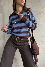 Sweater liviano de punto con diseño polo, cuello y puños en color marrón chocolate, y rayas horizontales alternadas entre azul y marrón. Cuenta con mangas largas y botones en el escote.
