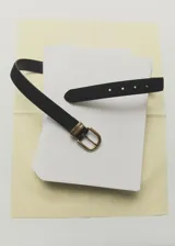 Cinturón de cuero vacuno color negro con hebilla metálica dorada de diseño clásico y pasador doble.