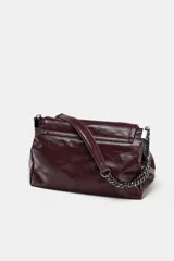 Bolso de hombro negro con detalle de costuras y tres compartimentos, uno con cierre de cremallera. Asa de hombro con cadena y cierre mediante imán.