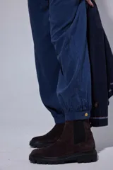 Pantalón tipo bombachita con pinzas que aportan volumen, confeccionado en Tencel. Presenta cierre frontal con botones dorados, bolsillos delanteros y ruedo ajustable mediante botón dorado.