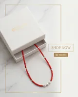 Collar de cuentas rojas con diseño central de tres perlas blancas separadas por pequeñas piezas de plata 925.