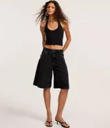 Blusa negra de punto roma, con diseño de cuello halter y espalda descubierta.