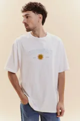 Remera de manga corta color blanco con cuello redondo. Presenta un estampado frontal con la palabra 'URUGUAY' en tipografía universitaria, un sol central en color dorado y la inscripción 'EST 1825'.