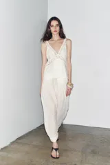 Top blanco de escote pico y tirantes finos, con detalle de encaje a tono y bajo recto.