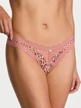 Tanga de tiro bajo confeccionado en microfibra ultrasuave con estampado de leopardo y delicados ribetes de encaje, adornado con una pequeña roseta frontal.