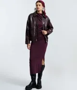 Campera bomber de poliuretano color marrón oscuro, con cuello clásico, cierre frontal con botones a presión, bolsillos delanteros con solapa, puños y bajo elásticos, y recortes estructurados.