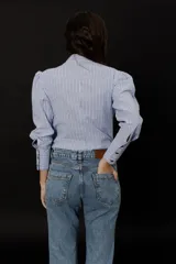 Jean celeste gastado de corte recto con cintura media entallada y pierna bootcut levemente oxford desde la rodilla.