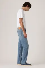 Pantalón de jean corte regular, con diseño clásico de cinco bolsillos, cierre de botón y cremallera, en tono azul medio con acabado desgastado.