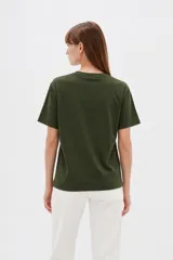 Remera de algodón blanca, de manga corta y cuello redondo, con estampado frontal de texto en color negro.
