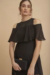 Vestido largo negro con hombros descubiertos, volados en el pecho, mangas cortas y paneles de encaje transparente en la falda.
