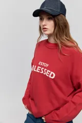 Sweater de punto marrón de tejido liviano y calce relajado, con hombros caídos, cuello redondo y puños y cintura en rib. Cuenta con una estampa tejida en el frente con la frase "Estoy Blessed" en color amarillo.