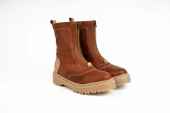 Bota tipo borcego de caña media, confeccionada en una combinación de cuero gamuzado negro y detalles en cuero color suela en la parte trasera y lengüeta. Presenta suela track de goma negra y costuras a la vista.
