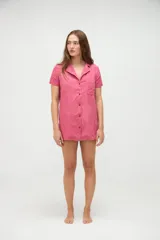 Vestido camisero de algodón con diseño a rayas verticales en tonos rosados y rojos, cuello camisero, manga corta, cierre frontal con botones y un bolsillo aplicado en el pecho.