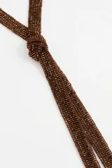 Collar largo tipo bufanda realizado en tejido de cuentas de vidrio color marrón cobrizo, con terminación de flecos.