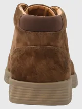 Bota de caña baja Hush Puppies, confeccionada en cuero gamuzado color marrón chocolate, con cierre de cordones al tono y suela de poliuretano con tecnología Spinal para mayor amortiguación y estabilidad.