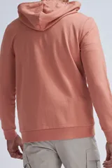 Chaqueta deportiva con cierre frontal, capucha ajustable con cordones y puños elásticos, en color rosa.