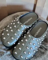 Zuecos negros de cuero vegano con tachas plateadas.