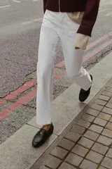 Mocasín de piel color negro con antifaz en la parte delantera y detalle de penny dorado. Tiene copete subido y punta redonda.