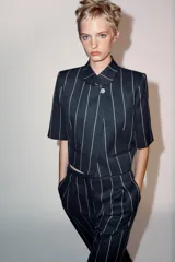 Chaqueta corta ZARA Woman Collection de diseño estructurado, color azul marino con patrón de rayas diplomáticas claras. Presenta cuello redondo mao, manga corta, falsos bolsillos de vivo en el delantero y cierre frontal cruzado con un botón.
